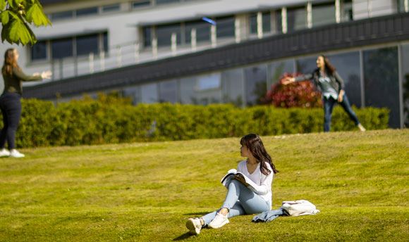 Students playing frisbee on the grass outside Ƶ, Edinburgh